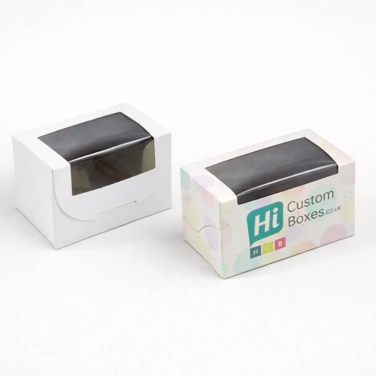 Two small white boxes with large clear windows- one plain and one with branded pastel patterns- class=